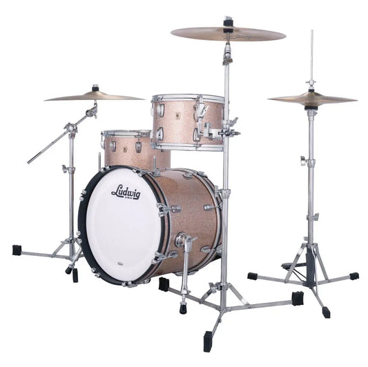 Ludwig drum kit with a shimmering rose gold finish, chrome hardware, a white front drum head, and two cymbals, shown on a solid white background.