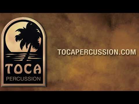 Toca Percussion logo featuring a palm tree and sunset, with the website address tocapercussion.com on a brown textured background.